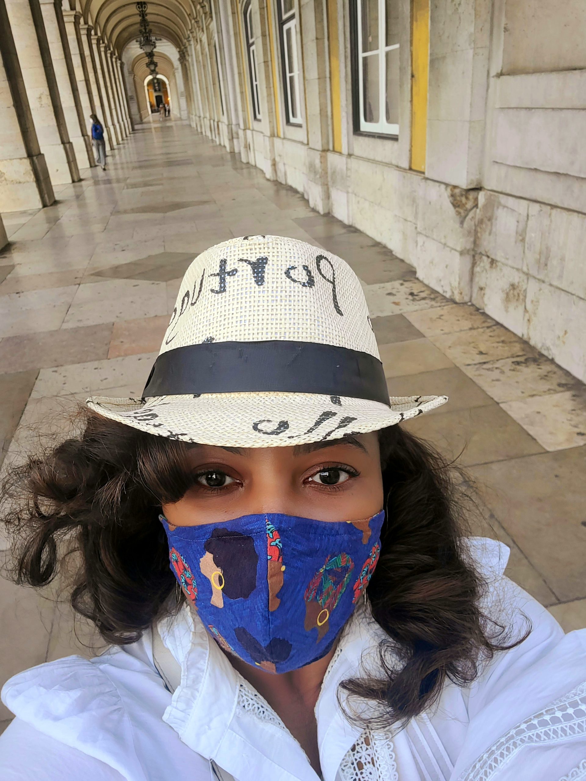 Author standing in Lisbon wearing a fedora that says Portugal